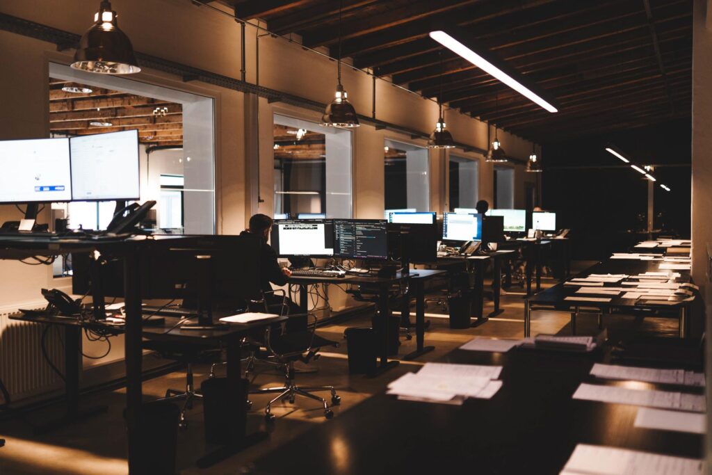 Modernes Großraumbüro von STROHBECKE in Herford mit mehreren Arbeitsplätzen und Mitarbeitenden bei der Arbeit an Computern – Symbol für Struktur, Teamarbeit und Digitalisierung.